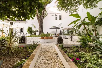 a garden in a white building with plants at Casa Palacio Rufina & Jardines in Jerez de la Frontera