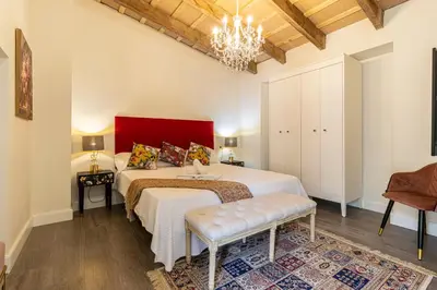 a bedroom with a large bed with a red headboard at Casa Palacio Rufina & Jardines in Jerez de la Frontera