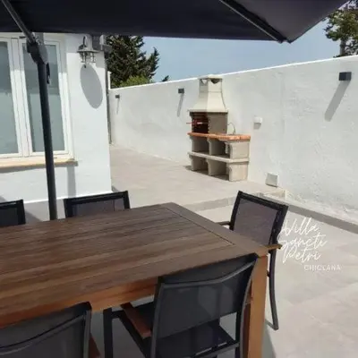 a wooden table and chairs on a patio at VILLA SANCTI PETRI in Chiclana de la Frontera