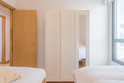 a bedroom with a white closet and a bed at Sherryflat Abrantes - Parking in Jerez de la Frontera