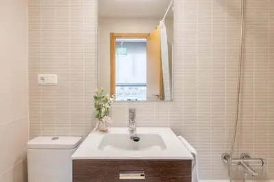 a bathroom with a sink and a toilet and a mirror at Sherryflat Abrantes - Parking in Jerez de la Frontera