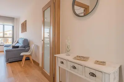 a living room with a table and a mirror on the wall at Sherryflat Abrantes - Parking in Jerez de la Frontera