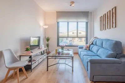 a living room with a blue couch and a table at Sherryflat Abrantes - Parking in Jerez de la Frontera