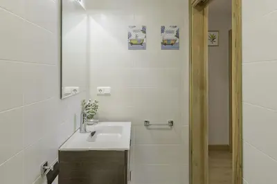 a white bathroom with a sink and a shower at Sherryflat Abrantes - Parking in Jerez de la Frontera