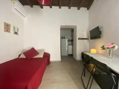 a living room with a red couch and a table at Apartamento La Flamencura in Jerez de la Frontera