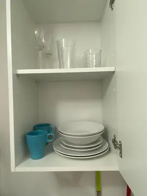 a white cabinet with plates and bowls and cups at Apartamento La Flamencura in Jerez de la Frontera