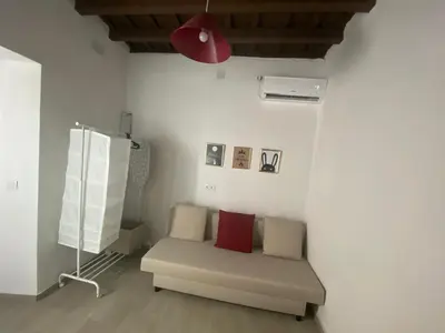a living room with a couch and a red lamp at Apartamento La Flamencura in Jerez de la Frontera