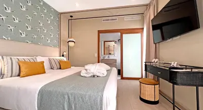 a bedroom with a large bed and a flat screen tv at Soho Boutique Columela in Cádiz