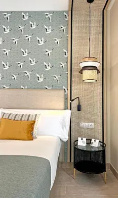 a bedroom with a bed and a wall with birds at Soho Boutique Columela in Cádiz