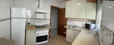 a kitchen with a white refrigerator and a sink at Apartamento Centro Playa in Sanlúcar de Barrameda