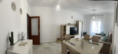 a living room with a table and a couch at Apartamento Centro Playa in Sanlúcar de Barrameda