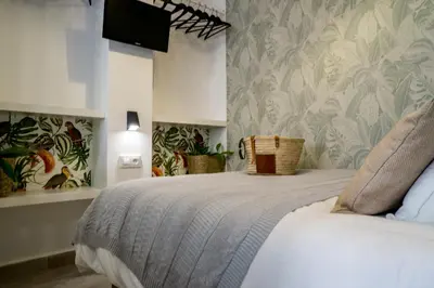 a bedroom with a bed with a tv on the wall at R&B Puerto Sherry Abohem in El Puerto de Santa María