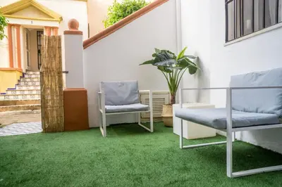 a patio with two chairs and green grass at R&B Puerto Sherry Abohem in El Puerto de Santa María
