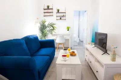 a living room with a blue couch and a tv at CDZ - Suarez de Salazar 1 y 2 in Cádiz