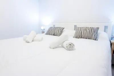 a white bed with white sheets and pillows at CDZ - Suarez de Salazar 1 y 2 in Cádiz