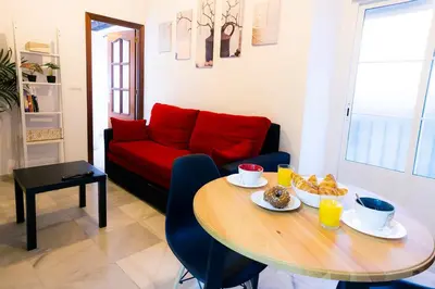 a living room with a table and a red couch at CDZ - Suarez de Salazar 1 y 2 in Cádiz