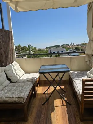 a balcony with a couch and a table and a view at Atico Capuchinos in Sanlúcar de Barrameda