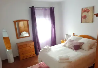 a bedroom with a bed and a dresser and a mirror at El Cano Playa Victoria Grupo AC Gestion in Cádiz