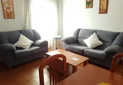 a living room with two couches and a table at El Cano Playa Victoria Grupo AC Gestion in Cádiz
