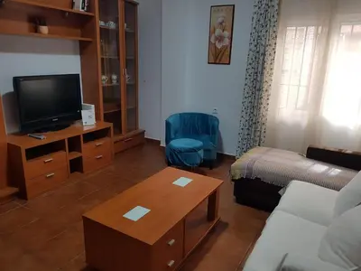 a living room with a couch and a tv at El Cano Playa Victoria Grupo AC Gestion in Cádiz