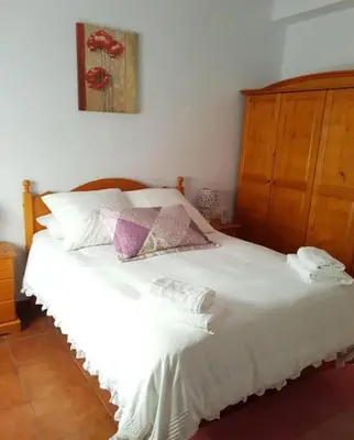 a bedroom with a white bed with a wooden headboard at El Cano Playa Victoria Grupo AC Gestion in Cádiz