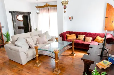 a living room with a couch and a glass table at Ático Imperial GARAJE GRATIS Céntrico Terraza Aire Acond Solarium 2 baños wifi a 1minuto de la Plaza Cabildo in Sanlúcar de Barrameda