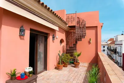 a building with a staircase and potted plants on it at Ático Imperial GARAJE GRATIS Céntrico Terraza Aire Acond Solarium 2 baños wifi a 1minuto de la Plaza Cabildo in Sanlúcar de Barrameda