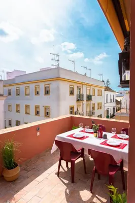 a patio with a table and chairs on a balcony at Ático Imperial GARAJE GRATIS Céntrico Terraza Aire Acond Solarium 2 baños wifi a 1minuto de la Plaza Cabildo in Sanlúcar de Barrameda