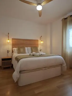 a white bedroom with a large bed with two lights at La Terraza de Gades Little Apartments in Cádiz