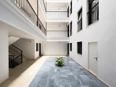an empty hallway with stairs and a potted plant at La Terraza de Gades Little Apartments in Cádiz