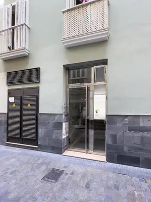 a store front with glass doors on a building at La Terraza de Gades Little Apartments in Cádiz
