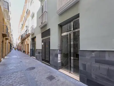 an empty street in a city with buildings at La Terraza de Gades Little Apartments in Cádiz