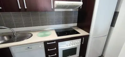 a small kitchen with a stove and a sink at BRISAMAR Rota ATLÁNTICO apartment in Rota