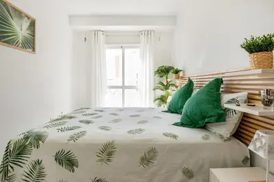 a bedroom with a bed with green pillows at BRISAMAR Rota ATLÁNTICO apartment in Rota