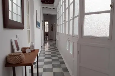 a hallway with a door and a checkered floor at Casa del Sur in Cádiz