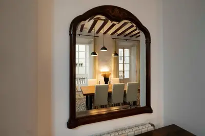 a mirror on a wall with a table and chairs at Casa del Sur in Cádiz
