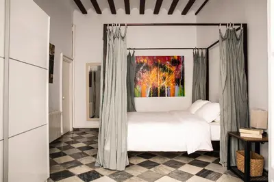 a bedroom with a canopy bed and a painting at Casa del Sur in Cádiz