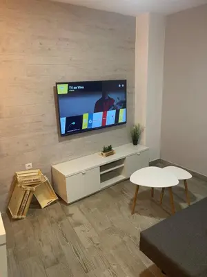 a living room with a flat screen tv on a wall at apartamentos Bandera in Jerez de la Frontera