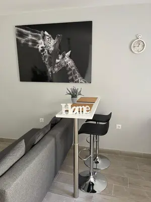 a table and stool next to a couch with a picture at apartamentos Bandera in Jerez de la Frontera