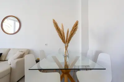 a glass table in a living room with a couch at Apartamentos El Capitan Veneno by Cadiz4Rentals in Cádiz