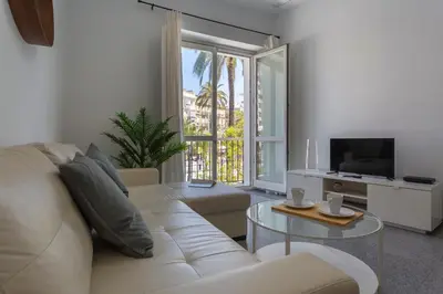 a living room with a white couch and a television at Apartamentos El Capitan Veneno by Cadiz4Rentals in Cádiz