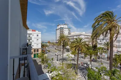 a view of a street with palm trees and buildings at Apartamentos El Capitan Veneno by Cadiz4Rentals in Cádiz
