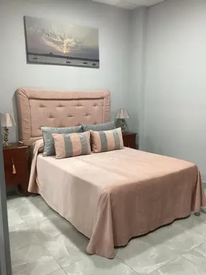 a bedroom with a large bed with a pink bedspread at María y Juan Apartamento con Garaje in Sanlúcar de Barrameda