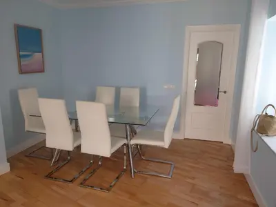a dining room with a glass table and white chairs at Cádiz San Pedro in Cádiz