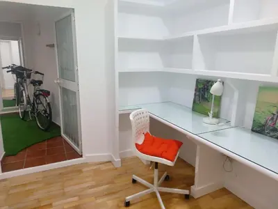 a white desk with a red chair in a room at Cádiz San Pedro in Cádiz