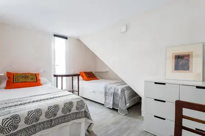 two beds in a room with white walls at Eva Recommends Sanlúcar City & Pool in Sanlúcar de Barrameda