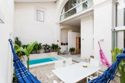 a patio with a white table and chairs and a swimming pool at Eva Recommends Sanlúcar City & Pool in Sanlúcar de Barrameda
