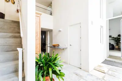 a room with white walls and a hallway with a plant at Eva Recommends Sanlúcar City & Pool in Sanlúcar de Barrameda