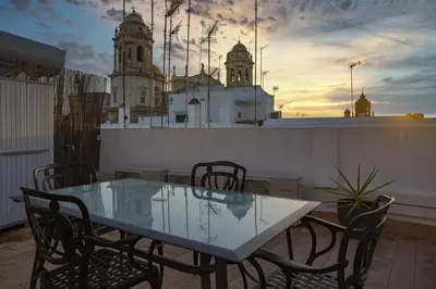 a glass table and chairs on a balcony with a building at Catedral VIEW Apartment by Cadiz4Rentals in Cádiz