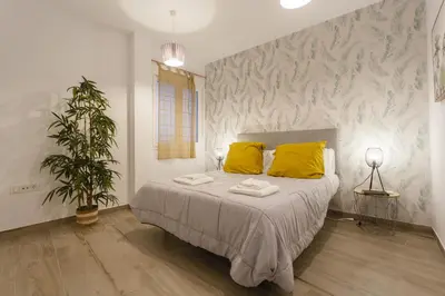 a bedroom with a bed with yellow pillows and a plant at Catedral VIEW Apartment by Cadiz4Rentals in Cádiz